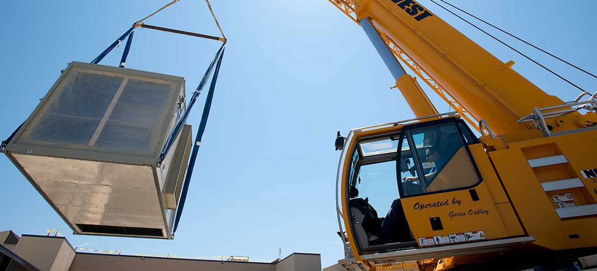 Yellow crane lifting custom Nortek air handler