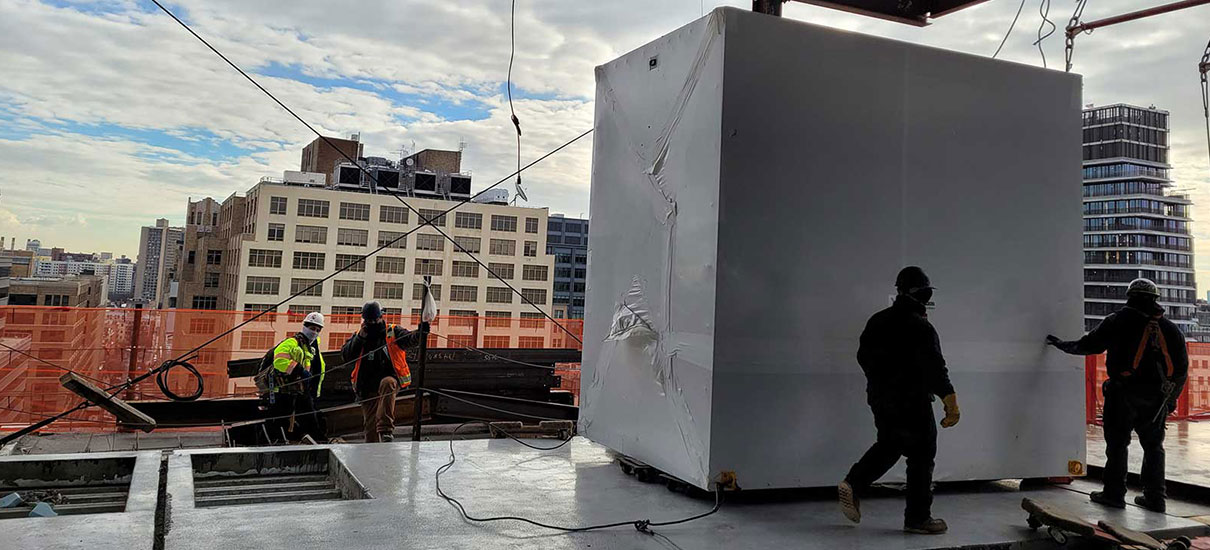 Men unhooking air handler on rooftop
