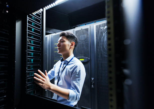 Man in blue shirt inspecting server