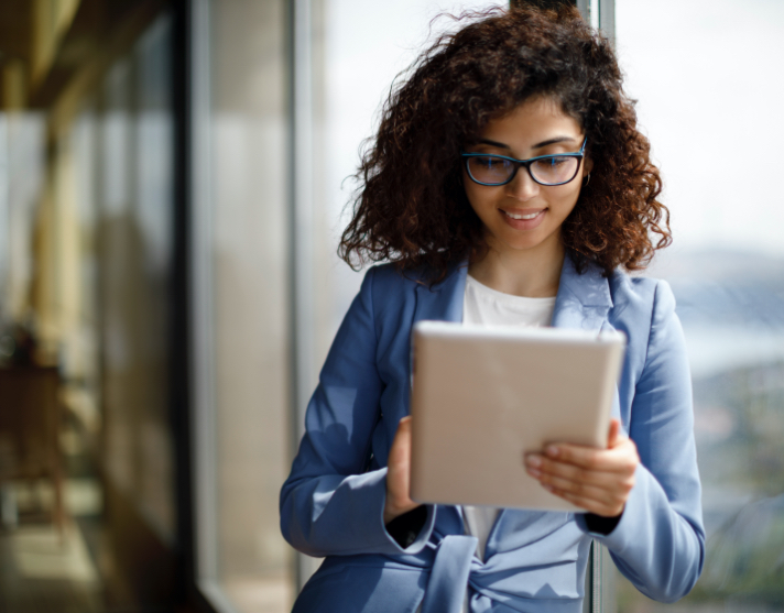 Young woman examines tablet in office building