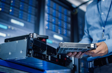 IT Engineer Installing Hardware Equipment into Server Rack