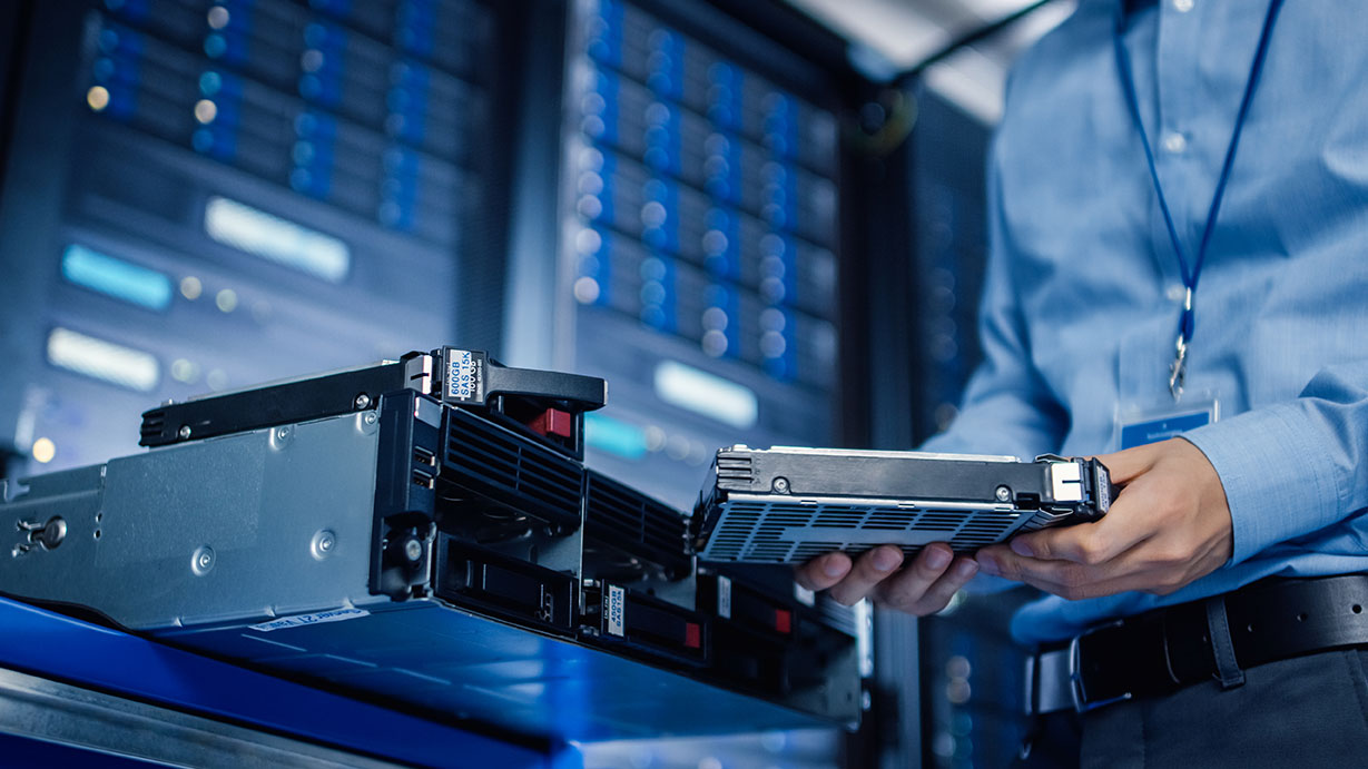 IT Engineer Installing Hardware Equipment into Server Rack
